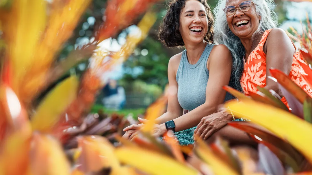 mom and daughter smiling in a garden